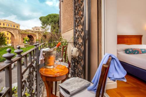 a room with a balcony with a bed and a table at Hotel Emona Aquaeductus in Rome