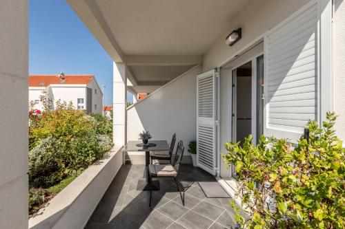 a balcony with a table and chairs on a house at Hvar De Luxe Apartments in Hvar