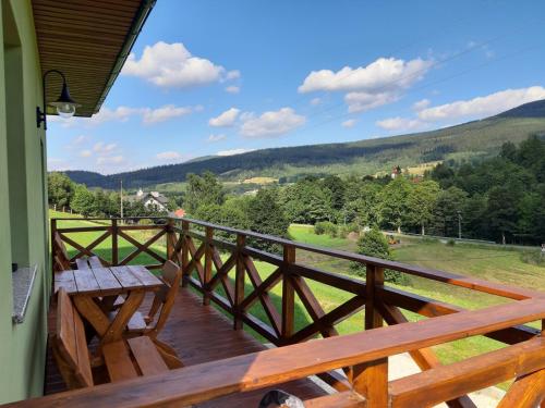 a balcony with a wooden railing and a picnic table at Górskie Zacisze Kamienica in Stronie Śląskie
