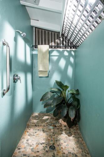 un bagno con una pianta nell'angolo della doccia di Chateau Nightwind a Lovenlund