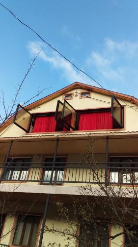 un bâtiment avec des rideaux rouges sur son côté dans l'établissement Resort Hotel surami, à Surami