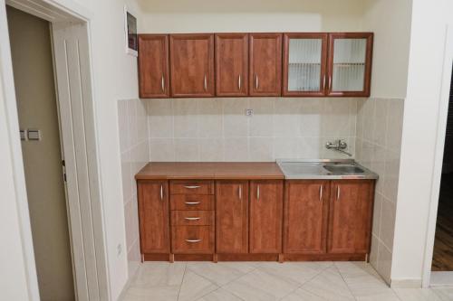 a kitchen with wooden cabinets and a sink at Apartments Klara in Utjeha