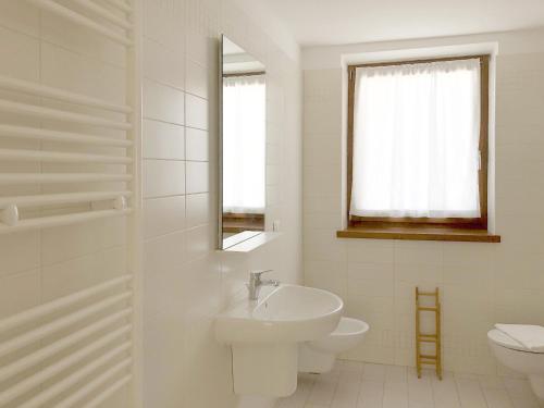 a white bathroom with a sink and a toilet at Residence Aurora in Lavarone