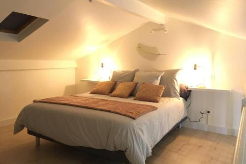 a bedroom with a large white bed with two pillows at Appartement neuf entre mer et montagne. in Furiani