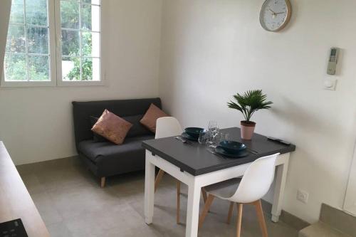 un salon avec une table et un canapé dans l'établissement Appartement neuf entre mer et montagne., à Furiani