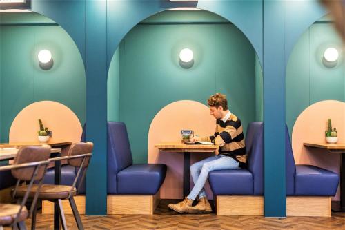 a man sitting at a table in a restaurant at Your Apartment I Clifton Village in Bristol