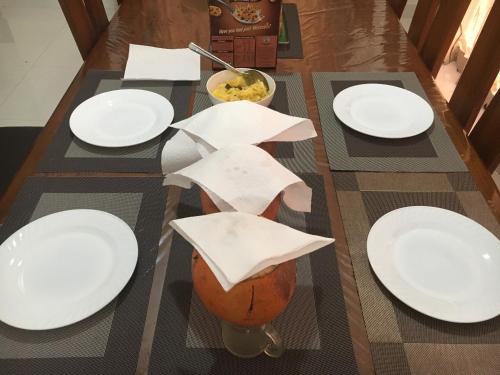a table with white plates on top of it at NegomboVilla in Negombo