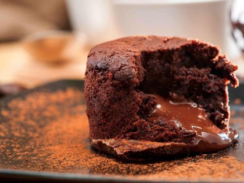 a chocolate cake sitting on top of a black plate at ibis Saint Germain en Laye Centre in Saint-Germain-en-Laye