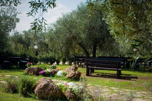 a park bench in a park with flowers and rocks at Agriturismo Il Solengo in Cretone