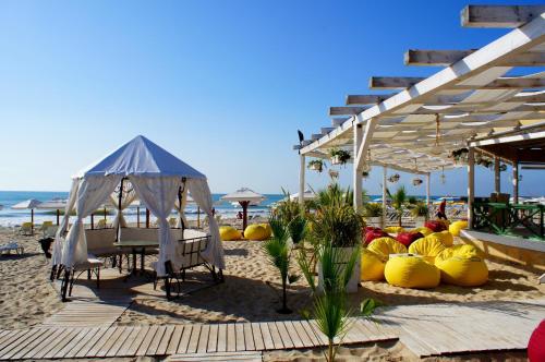 una playa con mesa y sillas y una tienda de campaña en Family Hotel Julian, en Kranevo