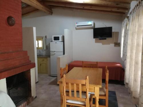 a kitchen and dining room with a table and a couch at Tardecitas del Atuel in Rama Caída