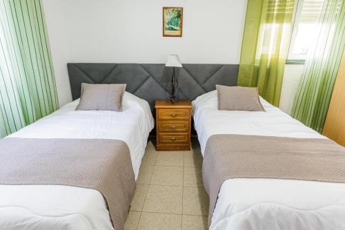 two beds sitting next to each other in a room at Hospedaria Australia in Velas