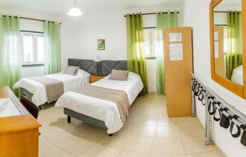 a hospital room with two beds and a mirror at Hospedaria Australia in Velas