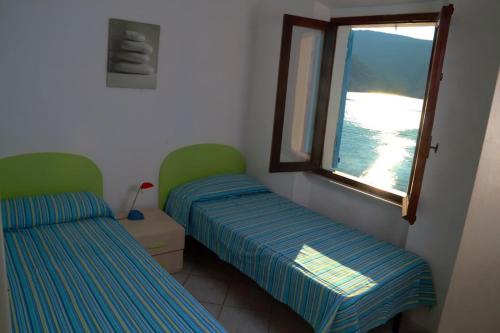 two beds in a room with a window at Ammiraglio in Campese