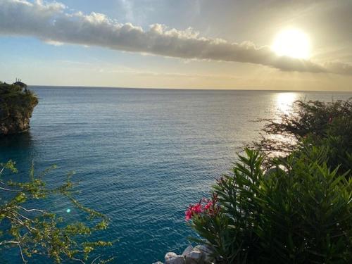 a view of a body of water with the sun setting at Blue Lagoon Apartment in Lagun