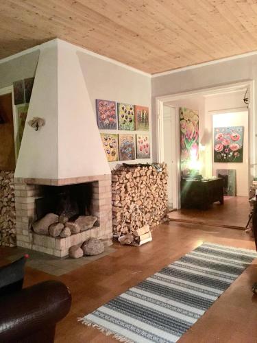 a living room with a fireplace and a pile of fire wood at Arthome Småland in Ruda