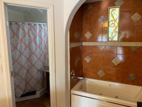 a bathroom with a tub and a tile wall at Chantico Inn in Ojai