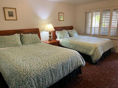 a bedroom with two beds and a lamp on a table at Chantico Inn in Ojai