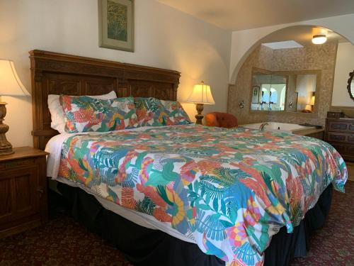a bedroom with a bed with a colorful comforter at Chantico Inn in Ojai