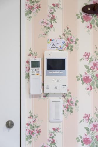 two machines are on a wall with flowers at nestay inn tokyo senju in Tokyo