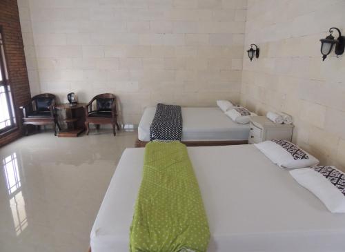 a room with three beds in a room at Lotus 2 Guest House in Borobudur