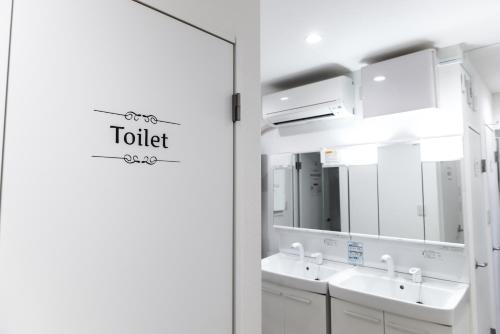 a bathroom with two sinks and a mirror at nestay inn tokyo senju in Tokyo