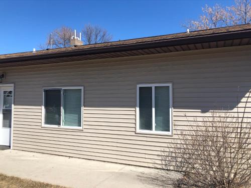 a house with two windows on the side of it at Burrel Avenue Apartments in Cooperstown