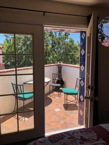 a room with a balcony with a table and chairs at Chantico Inn in Ojai