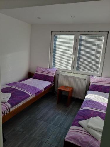a room with two beds and a table in it at S Apartmani Priboj in Čitluk