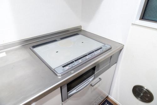 a small kitchen with a stove in a small room at nestay inn tokyo senju in Tokyo