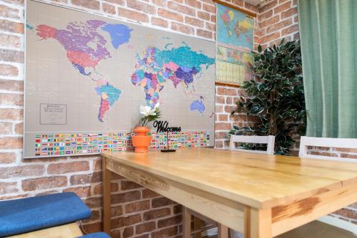 a wooden table in a room with a world map on the wall at nestay inn tokyo senju in Tokyo
