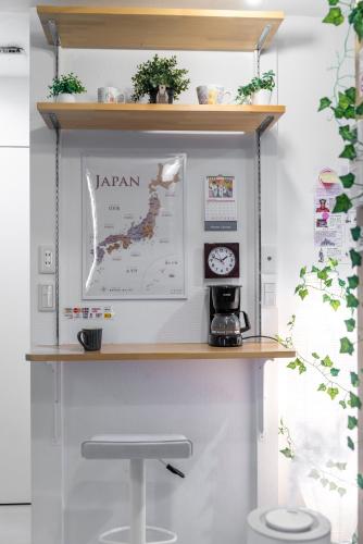 a shelf above a table with a stool at nestay inn tokyo senju in Tokyo