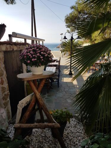 a table with flowers on it next to a beach at Marina in Nikiti