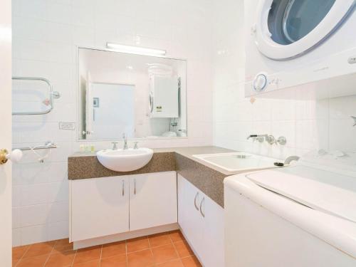 a white bathroom with a sink and a mirror at Avalon 4 in Yamba