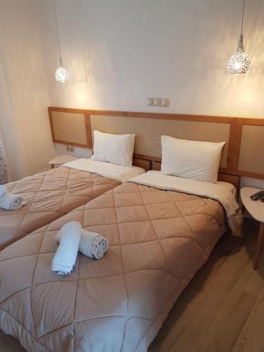 two beds in a hotel room with towels on them at Marina in Nikiti