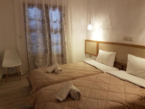 two beds in a hotel room with towels on them at Marina in Nikiti