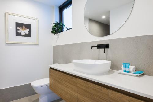 a bathroom with a white sink and a mirror at Allure Mooloolaba in Mooloolaba