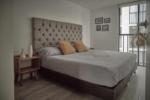 a bedroom with a large bed with a large headboard at Armónico departamento Ciudad de México in Mexico City