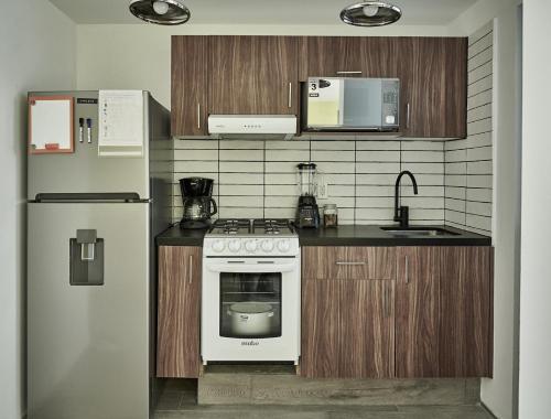 a kitchen with a white stove and a refrigerator at Armónico departamento Ciudad de México in Mexico City