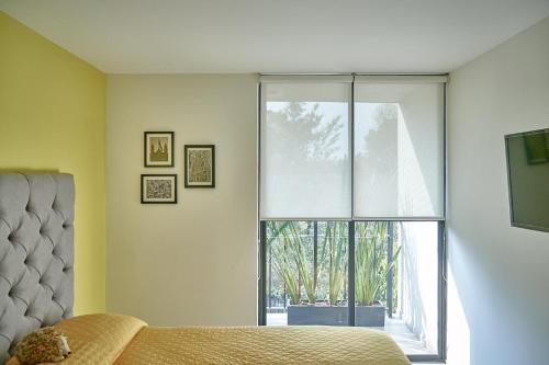 a bedroom with a bed and a large window at Armónico departamento Ciudad de México in Mexico City