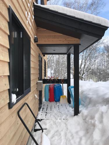 awning on a building with snow on the ground at Forest Hideaway in Niseko