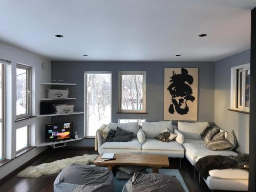 a living room with a couch and a table at Forest Hideaway in Niseko