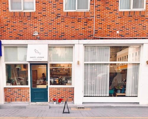 a brick building with a blue door on a street at Dante House in Busan