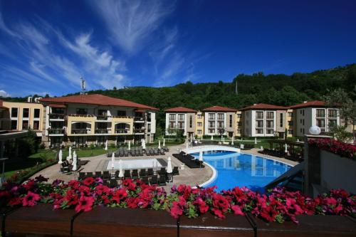a view of a resort with a pool and flowers at Pirin Park Hotel in Sandanski
