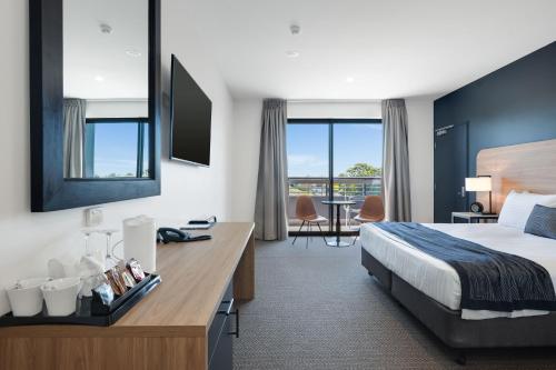 a hotel room with a bed and a desk at Springs Newcastle in Newcastle