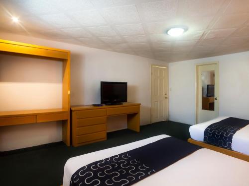 ein Hotelzimmer mit 2 Betten und einem Flachbild-TV in der Unterkunft Hotel Regis in Mexicali