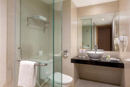 La salle de bains est pourvue de toilettes, d'un lavabo et d'une douche. dans l'établissement Swiss-Belinn Gajah Mada Medan, à Medan