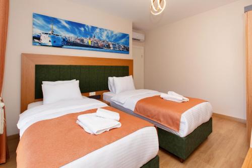 a bedroom with two beds with towels on them at Armoni Deluxe Suites Trabzon in Trabzon