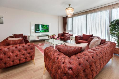 sala de estar con sofá rojo y sillas en Armoni Deluxe Suites Trabzon, en Trabzon