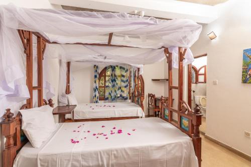 een slaapkamer met twee bedden met roze bloemen erop bij JoysVilla Family Holiday Home in Malindi